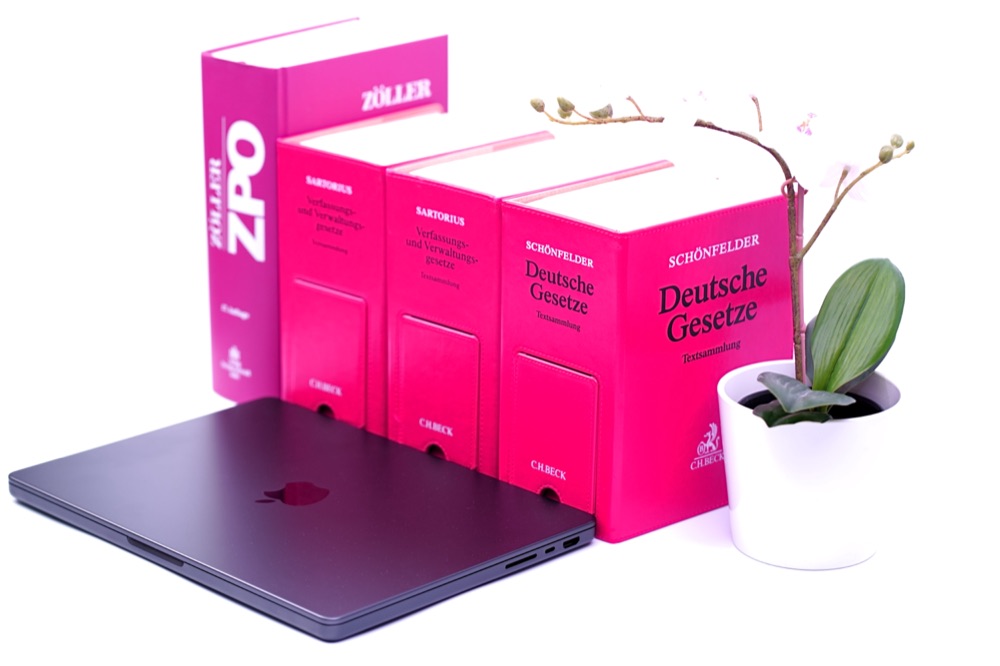 Gesetzessammlungen neben einem Laptop